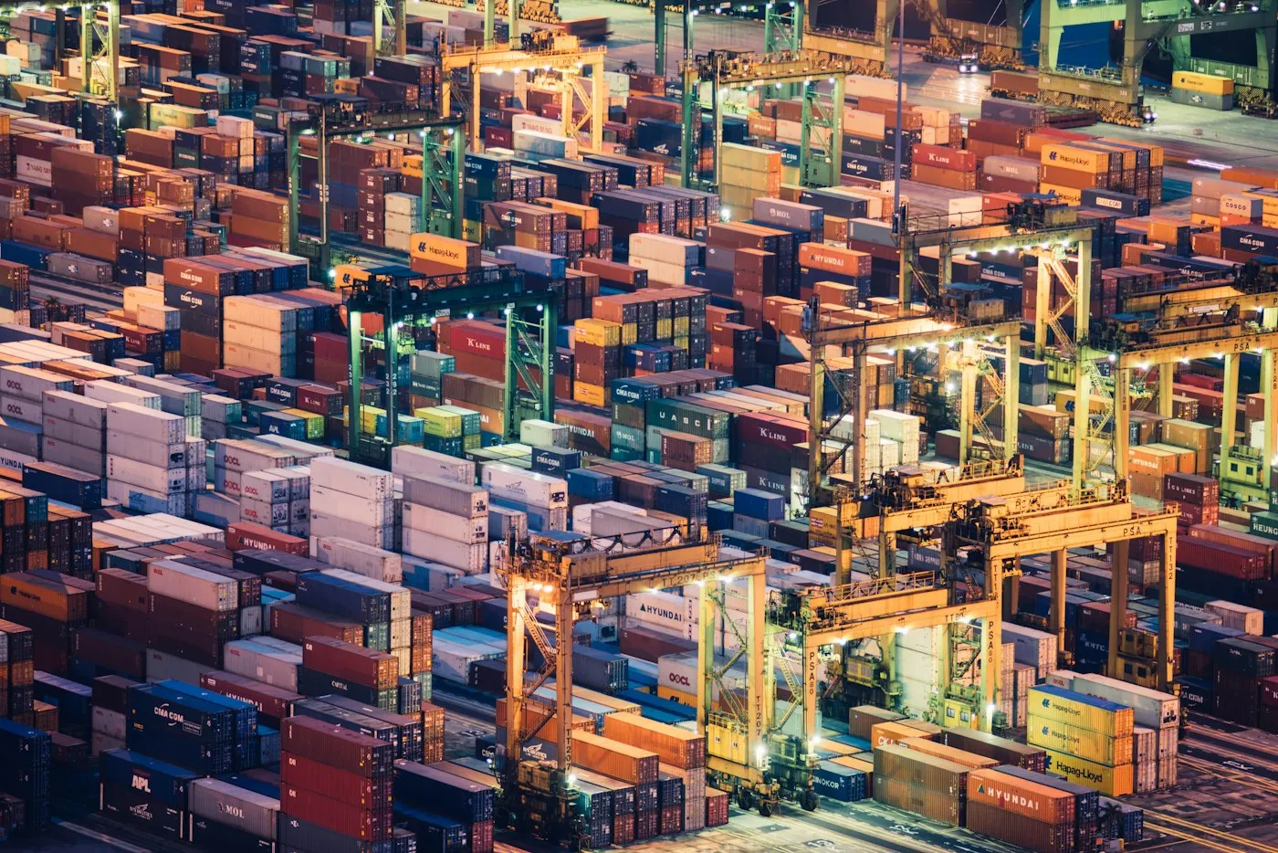 Containers and cargo ships at a working port at dusk